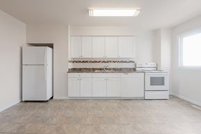 Edmonton apartment for rent - A kitchen with white appliances and cabinets.