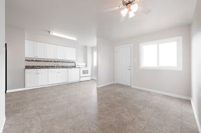 Edmonton apartment for rent - A spacious empty room with a ceiling fan and a window.