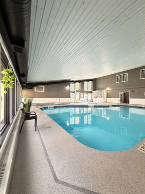 Edmonton apartment for rent - A balcony overlooks a parking lot and buildings.