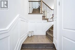 Toronto (Birchcliffe-Cliffside) house for rent - A staircase with a white wall and a wooden handrail.