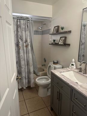 Deltona house for rent - A bathroom with a toilet, sink, and shower.