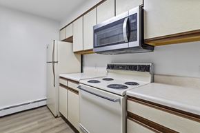 Altoona apartment for rent - A kitchen with a white stove and a microwave above it.