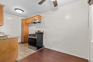 Burbank apartment for rent - A kitchen with a black stove top oven and a wooden cabinet.