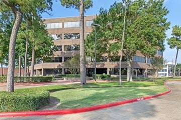 Houston apartment for rent - A large building with a red curb in front of it.