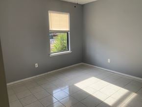 Pensacola house for rent - A room with a window and tiled floor.