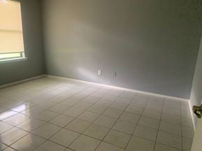 Pensacola house for rent - A room with a white tile floor and a window with blinds.