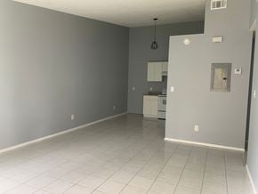 Pensacola house for rent - A spacious room with a kitchenette in the background.