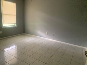 Pensacola house for rent - A room with a tiled floor and a window with blinds.