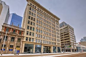 Edmonton house for rent - A large, old building with many windows sits in front of a modern skyscraper.