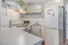 Edmonton house for rent - A white refrigerator with a few magnets on it is in a kitchen.