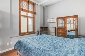 Edmonton house for rent - A bedroom with a bed, dresser, and window.