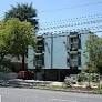 Burbank apartment for rent - A large grey building with a lot of windows and a tree in front of it.