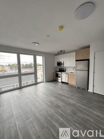 Lowell apartment for rent - A spacious kitchen with wooden cabinets and a refrigerator.