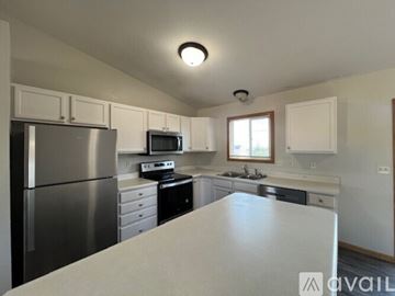 Rapid City house for rent - A kitchen with a stainless steel refrigerator and white countertops.