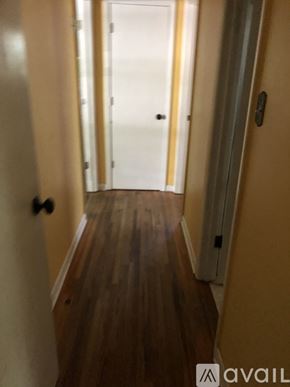 North Little Rock house for rent - A hallway with a wooden floor and white walls.