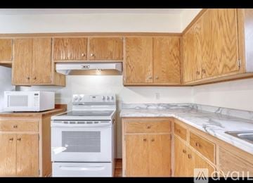 Milwaukee house for rent - A kitchen with wooden cabinets and a white oven.