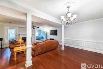 Atlanta townhouse for rent - A living room with a brown couch and a chandelier.