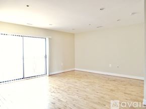 Washington apartment for rent - A spacious room with wooden flooring and a sliding glass door.