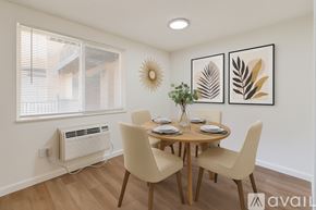 Aurora apartment for rent - A dining room with a table set for two and a wall art of a leaf.