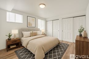 Aurora apartment for rent - A well-lit bedroom with a large bed and a wooden nightstand.