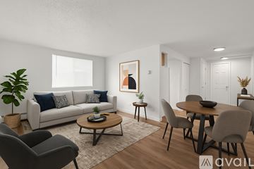 Aurora apartment for rent - A living room with a grey couch, a wooden coffee table, and a dining table with grey chairs.