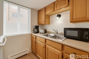 Aurora apartment for rent - A kitchen with wooden cabinets and a black microwave.