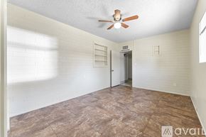 Mesa apartment for rent - A room with a ceiling fan and a door leading to another room.