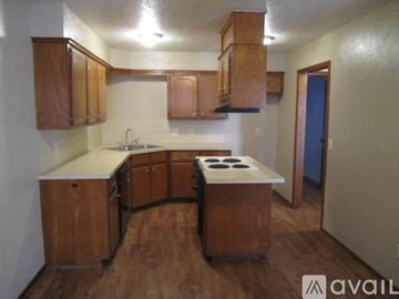 Oklahoma City house for rent - A kitchen with wooden cabinets and a white countertop.