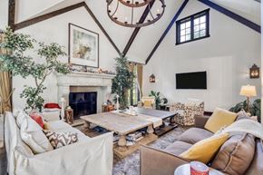 Winnipeg house for rent - A living room with a fireplace and a chandelier.