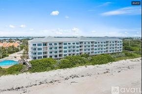 Melbourne Beach apartment for rent - A beachfront building with a pool and a clear sky.