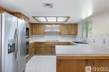 Fresno house for rent - A kitchen with wooden cabinets and a refrigerator.