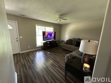 Pooler house for rent - A living room with a television, couch, and a table with a lit candle on it.