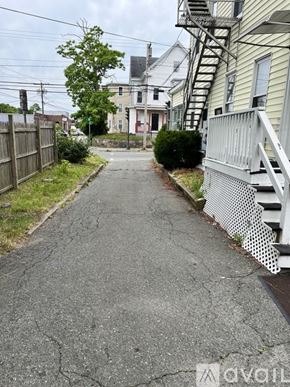 Brockton apartment for rent - A residential street with houses on both sides and a fire escape on the right.