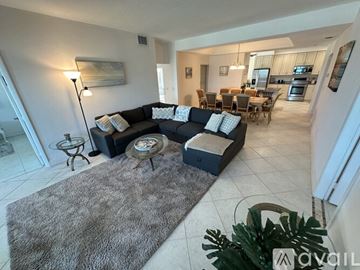 Melbourne Beach condo for rent - A living room with a grey rug and a black couch.