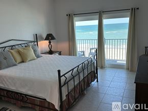 Melbourne Beach condo for rent - A bedroom with a large bed and a view of the beach.