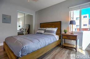 San Diego condo for rent - A bedroom with a large bed and a wooden nightstand.