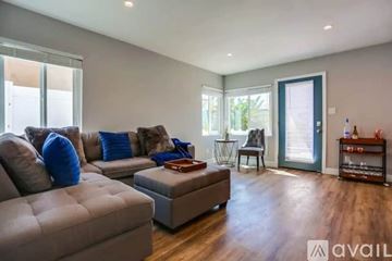 San Diego condo for rent - A living room with a grey couch and a brown ottoman.