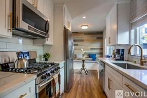 San Diego condo for rent - A modern kitchen with a stove top oven and a refrigerator.