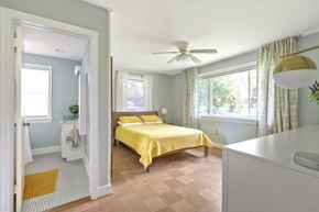 Richmond house for rent - A bedroom with a yellow bedspread and a white bed.