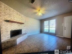 Texarkana apartment for rent - A living room with a fireplace and a ceiling fan.