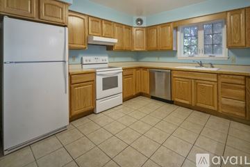 Ithaca apartment for rent - A kitchen with wooden cabinets and a white refrigerator.