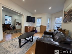 Boston apartment for rent - A living room with a brown couch, a coffee table, and a ceiling fan.