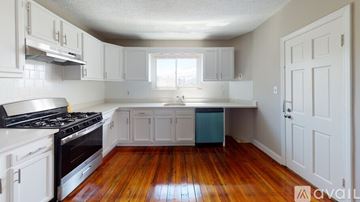 Somerville apartment for rent - A kitchen with white cabinets and a black stove top.
