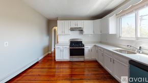 Somerville apartment for rent - A kitchen with white cabinets and a wooden floor.