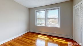 Somerville apartment for rent - A room with wooden floors and a window overlooking a street.