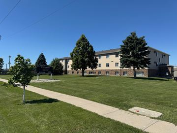 Fargo apartment for rent - A grassy area in front of a building with a sign that reads "Crimson".