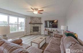 Oconomowoc house for rent - A living room with a fireplace and a large couch.