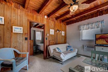 Englewood apartment for rent - A living room with a white couch and a wooden wall.