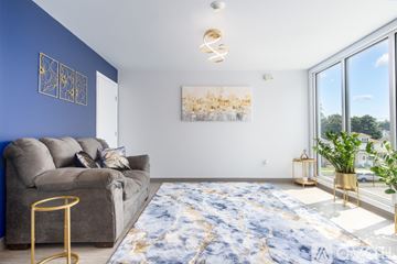 Johnson City apartment for rent - A living room with a grey couch, a gold side table, and a large painting on the wall.