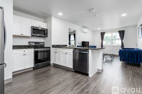 Johnson City apartment for rent - A modern kitchen with white cabinets and black appliances.